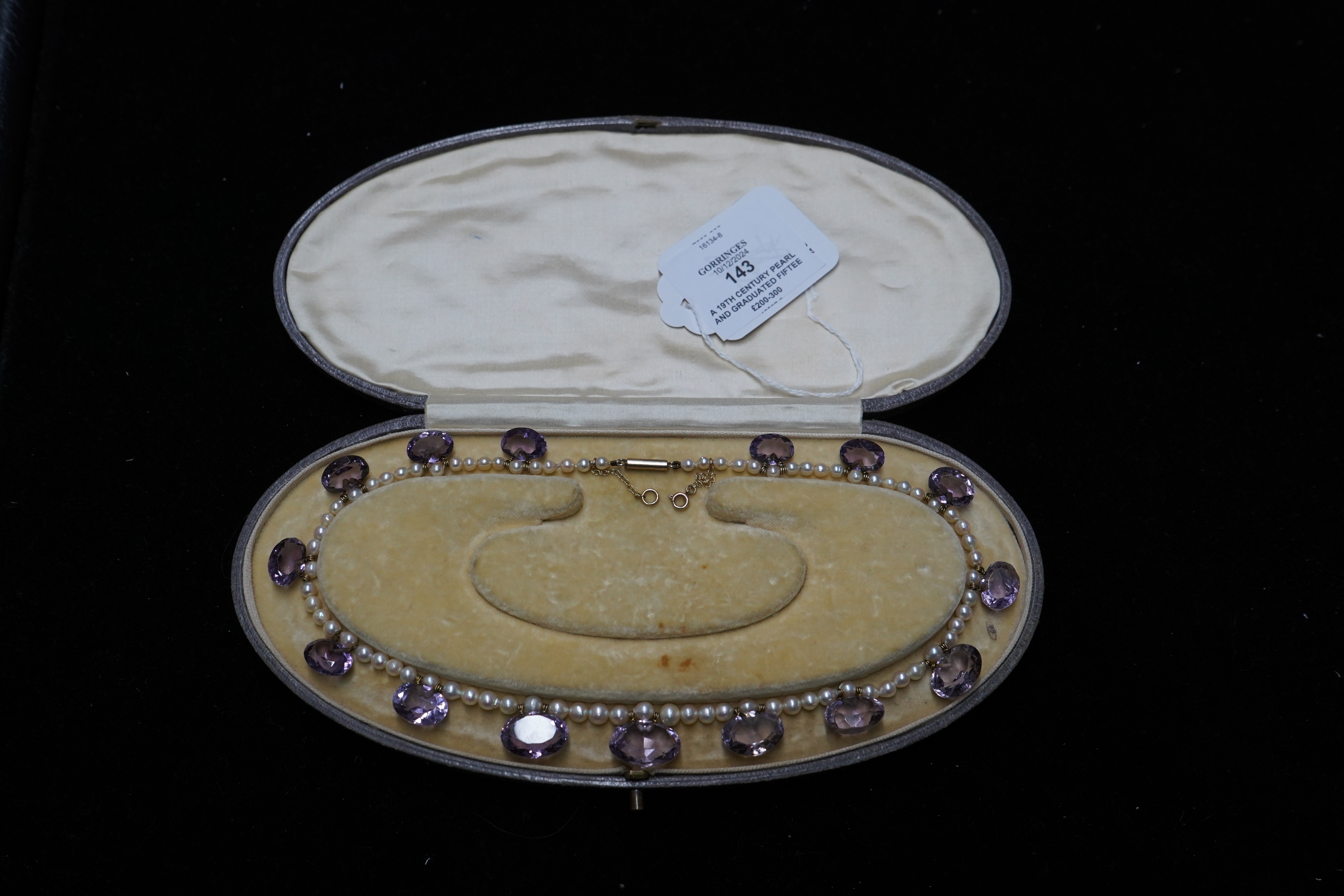 A 19th century pearl and graduated fifteen stone oval cut amethyst set drop necklace, with a gold barrel shaped clasp